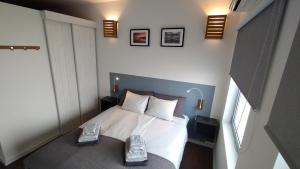 a bedroom with a bed with two shoes on it at Casinha Secreta - A Gema Escondida da Santa Luzia in Santa Luzia