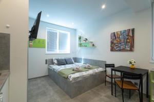 a room with a bed and a table in it at DORM BG pet-friendly Aparthotel in Stara Zagora