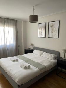 a bedroom with a bed with two towels on it at Exyca Tetuán in Madrid
