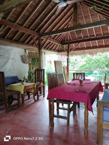 a dining room with a table with a purple table cloth at Lara Homestay in Kuta Lombok