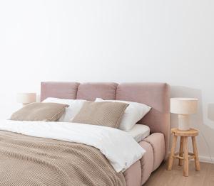 łóżko z białą pościelą i poduszkami w pokoju w obiekcie Apartament Węglowa 21 w Żywcu
