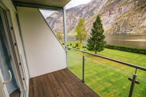 uma varanda com vista para um lago e para as montanhas em Lærdal Hotel em Lærdalsøyri