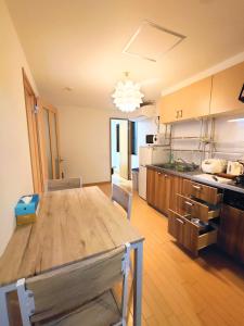 a large kitchen with a wooden table in a room at kaneshiro guest house in Tokyo