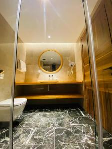 bagno con lavandino e specchio di Askireg Hotel 