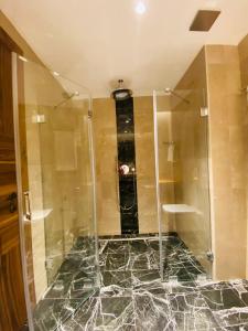 a shower with a glass door in a bathroom at Askireg Hotel 