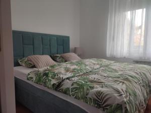 a bedroom with a large bed with a green headboard at Apartman Green City with garage in Banja Luka
