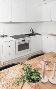 a kitchen with white cabinets and a sink and a table at Apartament Węglowa 21 in Żywiec