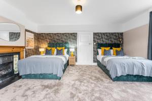 um quarto com 2 camas e uma lareira em Stunning 4-bed - Garden - Sleeps 14 em Bristol