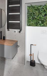 a bathroom with a toilet and a plant on the wall at Apartament Węglowa 21 in Żywiec