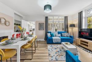 a living room with a blue couch and a table at Stunning 4-bed - Garden - Sleeps 14 in Bristol