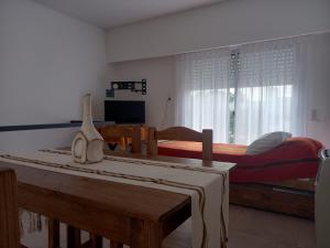 a bedroom with a bed and a table and a window at DEPARTAMENTOS GCHU in Gualeguaychú