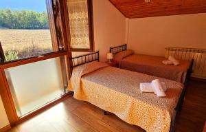 a bedroom with two beds and a large window at CASA COTIELLA RAÑIN in Rañín