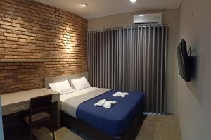 a bedroom with a bed and a desk with at The Heritage Karawaci in Binong +14 photos