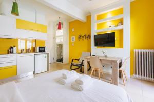 a kitchen with yellow walls and a bed in a room at Relaxing studio in Athens city center in Athens