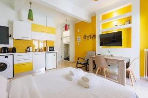 a kitchen with yellow walls and a table in a room at Relaxing studio in Athens city center in Athens