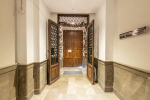 a hallway with a wooden door in a building at BiBo Suites Plaza Nueva in Granada