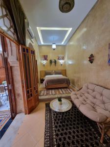 a bedroom with a bed and a couch and a table at RIAD LALLA ZINEB in Rabat