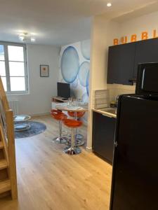 a room with a kitchen with a table and a refrigerator at Le Bubble - Centre Ville - La Bonne Marienne in Angers