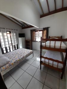 Pousada Maria do Mar في غاروبابا: غرفة نوم بسريرين بطابقين وتلفزيون