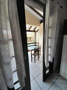 Habitación con puerta que da a un patio con mesa. en Pousada Maria do Mar, en Garopaba