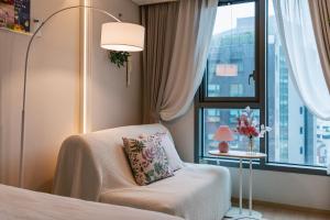 a bedroom with a bed and a chair and a window at Stay Seoul N Myeongdong in Seoul