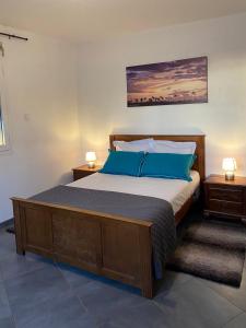 ein Schlafzimmer mit einem großen Bett mit blauen Kissen in der Unterkunft Ferme l'Eau de Coco in Saint-Paul
