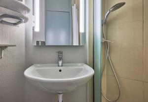 a bathroom with a sink and a shower at B&B HOTEL Caen Mémorial in Caen +15 photos