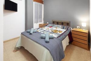a bedroom with a bed with a blue blanket at Senda el Cantal 3habitaciones Beach in Cala del Moral