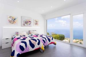 a bedroom with a bed and a large window at Vivienda vacacional de lujo en el sauzal in Sauzal