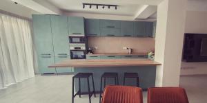 a kitchen with blue cabinets and a counter with stools at Mgarr ix-Xini Holiday apartment in Xewkija