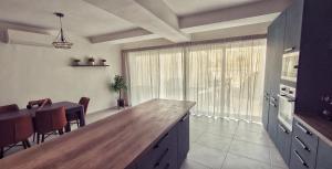 a kitchen with a large window and a dining table at Mgarr ix-Xini Holiday apartment in Xewkija