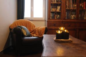 Cette chambre comprend une chaise et une table avec une bougie. dans l'établissement Gîte du Chat noir (Brocéliande), à Campénéac