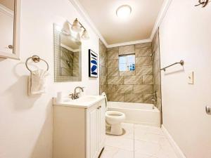 a bathroom with a sink and a toilet and a tub at Stylish 4-BR Abode - ROG in Los Angeles