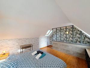 a bedroom with a blue bed and a staircase at Santorin, duplex chaleureux in Reims