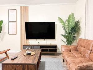 un soggiorno con divano e TV a schermo piatto di Stylish 4-BR Abode - ROG a Los Angeles