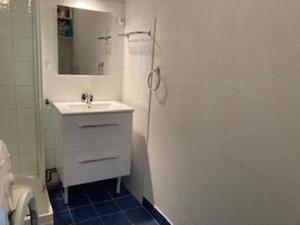 une salle de bain blanche avec un lavabo et un miroir dans l'établissement Appartement F2 Confortable à Amélie-les-Bains – Balcon, Parking, Proche Thermes, Animaux Bienvenus - FR-1-703-15, à Amélie-les-Bains-Palalda 3 autres photos