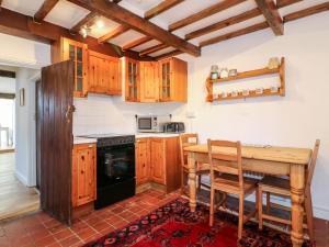 a kitchen with wooden cabinets and a wooden table at 35 Main Street in Nottingham