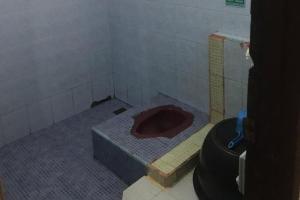 a dirty bathroom with a toilet in a room at SPOT ON 93378 Lona Guest House Syariah in Parit