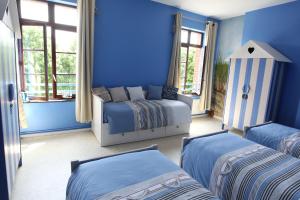 - une chambre avec 2 lits et des murs bleus dans l'établissement Les Pommes d'Or, à Marly-Gomont