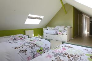 a attic bedroom with two beds and a window at Les Pommes d'Or in Marly-Gomont