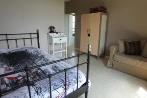 ein Schlafzimmer mit einem Bett und einem Sofa in der Unterkunft Les Pommes d'Or in Marly-Gomont