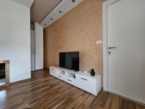 een woonkamer met een flatscreen-tv op een witte kast bij L&V Apartmani in Novi Grad