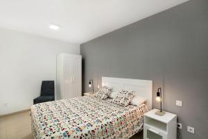 um quarto com uma cama e uma cadeira em Sunrise Arinaga em Arinaga