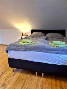 Una cama con dos toallas verdes encima. en Apartment, Boxspringbett, ruhige Lage, Kassel Nähe, en Schauenburg