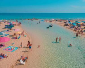 贝瓦尼亚圣彼得Villa Vacanze Perla del Salento - Casa Vacanze San Pietro in Bevagna - SALENTO - Puglia - ITALY的一群人在沙滩上与大海