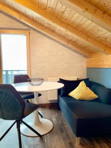ein Wohnzimmer mit einem blauen Sofa und einem Tisch in der Unterkunft Vintage-Hotel Charivari- Sommerbergbahnen 2024 kostenlos in Bolsterlang