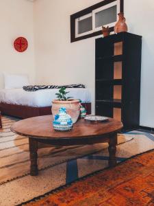 a living room with a table with a plant on it at CHILL SURFER HOSTEL in Tamraght Ouzdar