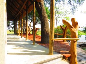 un porche de madera con un banco en un paseo marítimo en Zambezi King Fisher Lodge, en Katima Mulilo