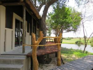 un banco de madera en el porche de una casa en Zambezi King Fisher Lodge en Katima Mulilo