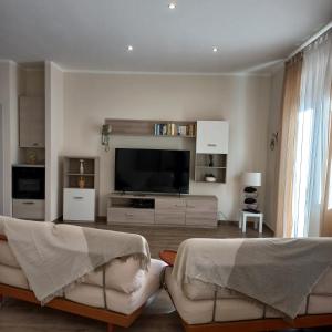 a living room with two couches and a flat screen tv at la casa di Carla in Pescara